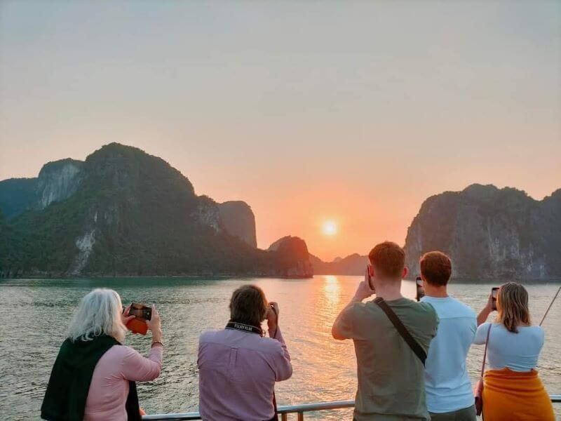 Travelers watching a beautiful sunset on a cruise in Lan Ha Bay
