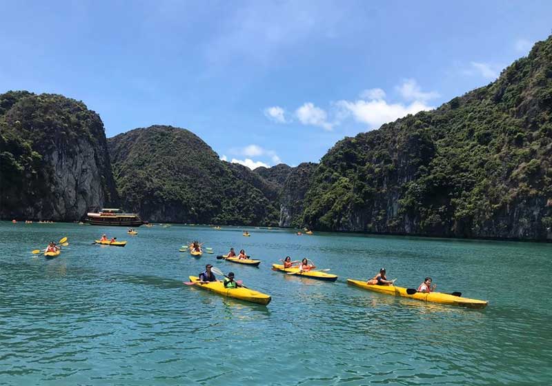 Group kayaking in Lan Ha Bay surrounded by limestone mountains